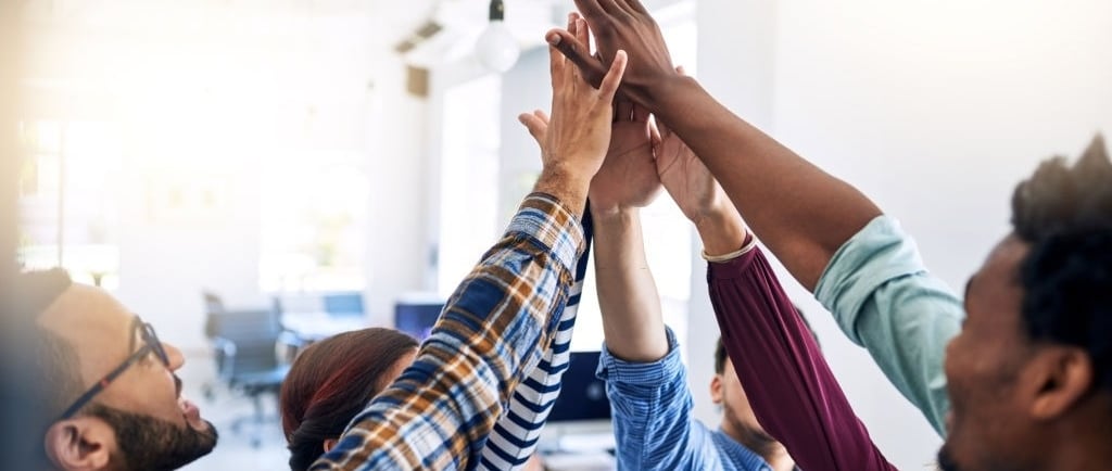 a group of African people holding hands up in the air