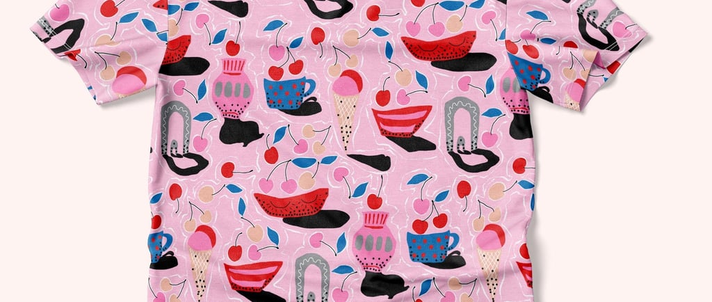 a pink shirt with a pattern of a kitchen utensils and cherries