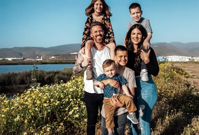 large young caucasian family smiling at sunset by a river in the country