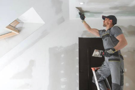 taper finishing drywall on the ceiling
