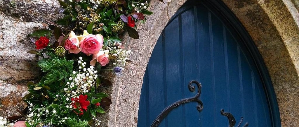 blue church door with flowers around the arch