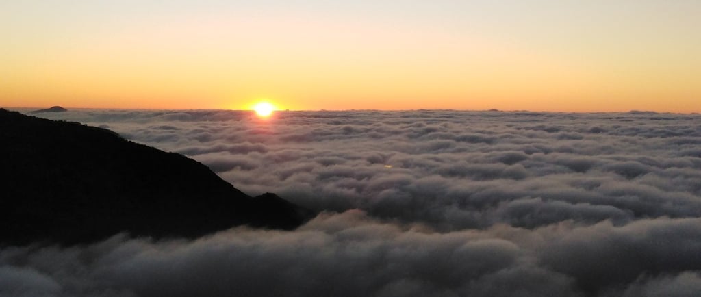 a sunset over a mountain range with a sunset