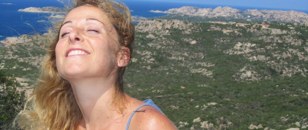 a woman in a blue dress is smiling and looking up at the sky