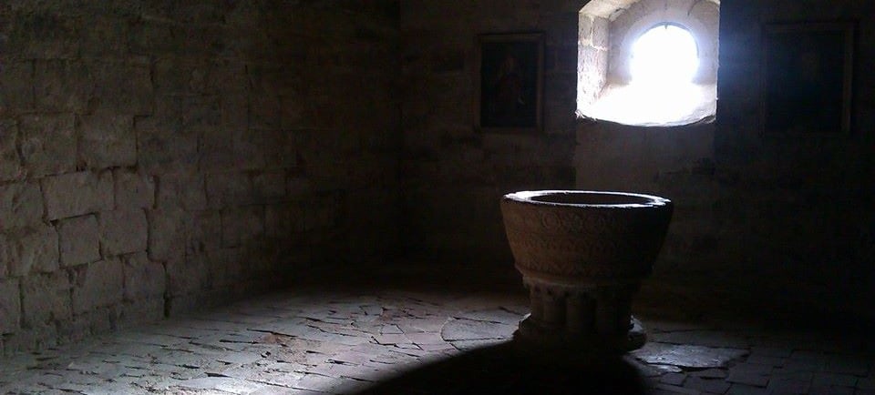 a stone urn in a stone wall with a window