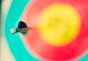 A single arrow hitting the center of a colorful bullseye target for success and goal achievement.