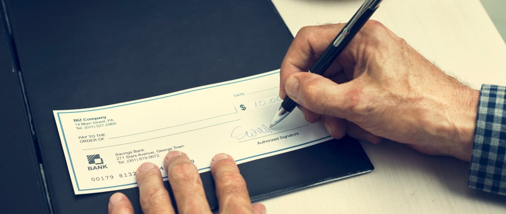 Home Seller writing a real estate commission check to his realtor