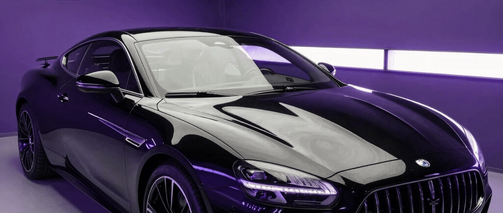 Sleek black luxury sports coupe parked in a modern showroom with purple neon lighting.