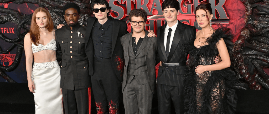 a group of people standing in front of a red carpet