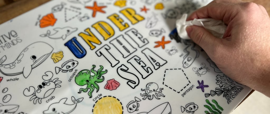 Wiping clean a Scribbly Kids reusable drawing mat for mess-free play and easy learning