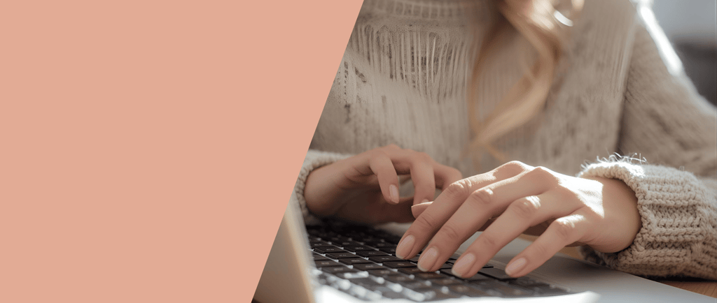 a woman's hands typing on a laptop computer