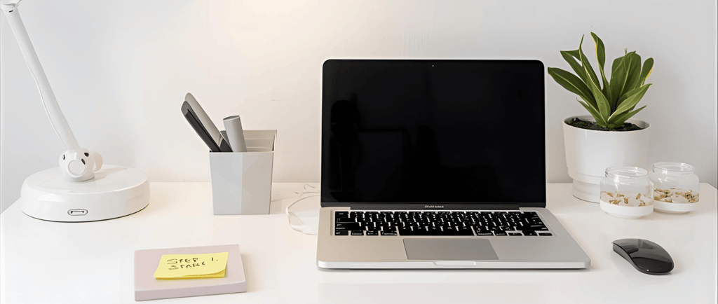 a laptop computer sitting on a desk with a lamp
