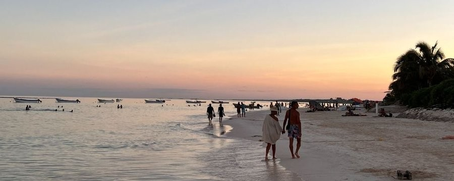 Die Geschichte vom Fischer und dem Geschäftsmann. Strand mit Fischerbooten im Hintergrund.