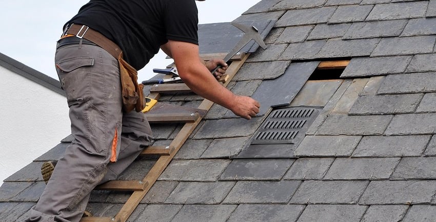 Roofing Specialists Yorkshire. Roofer repairing damaged roof tiles