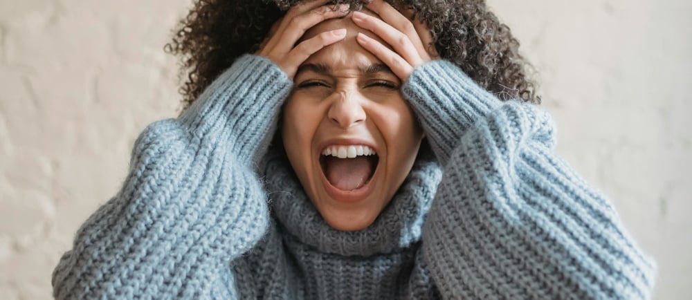a woman with curly hair and a blue sweater