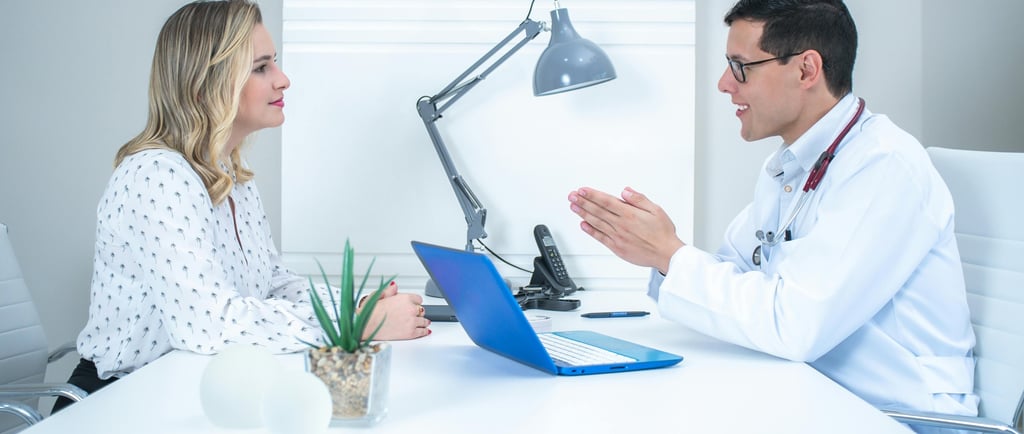 Arzt mit Patientin am Schreibtisch, Diskutieren  