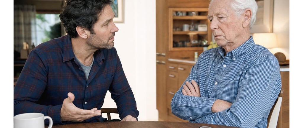 Adult son having a calm, caring conversation with his resistant senior father who refuses help