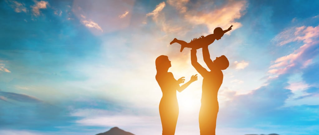 Familia en el firmamento con un niño en brazos