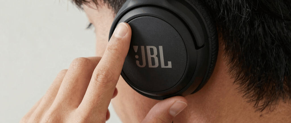 a man wearing headphones standing in front of a sign