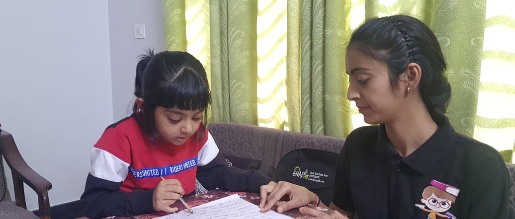 A Gharpadh tutor sitting on a couch with a child teaching