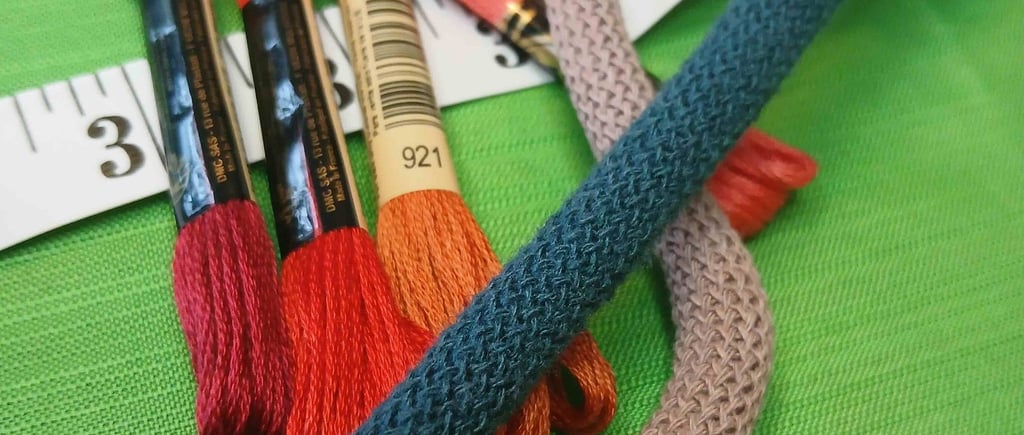 a bunch of thread - wrapped thread threads and scissors