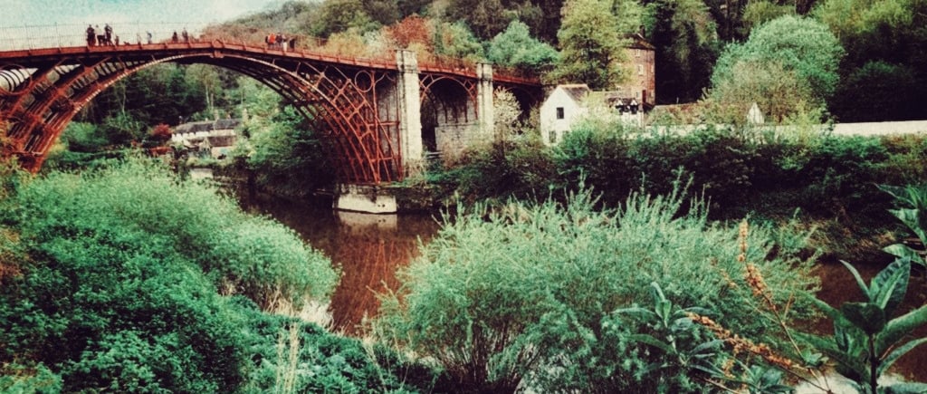 The historic Iron Bridge over the River Severn in Shropshire surrounded by lush green trees.