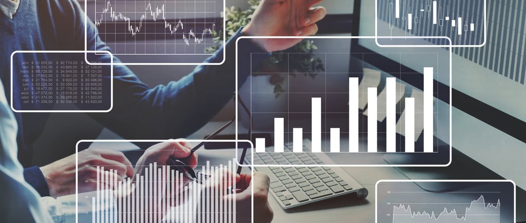 a man in a suit and tie is working on a computer monitoring personal financial reports