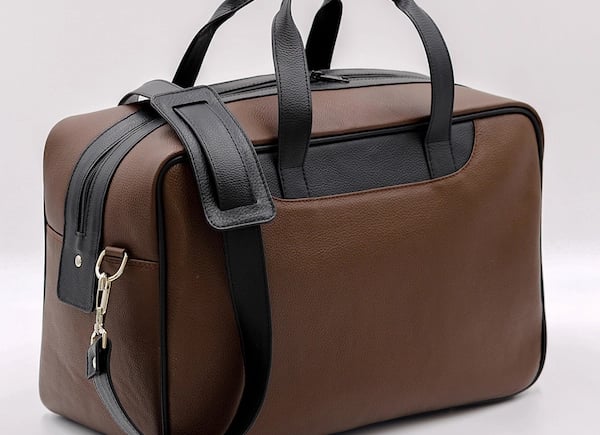 a brown and black bag with a keychaik