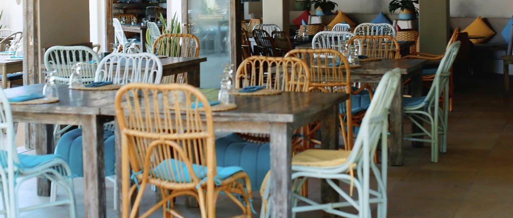 Empty cafe interior in Vietnam with bamboo-style chairs, cushions and simple tables