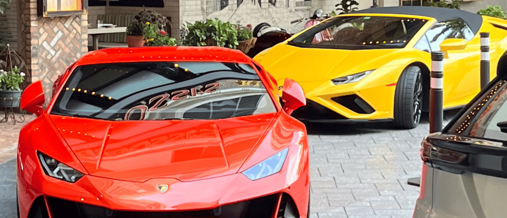 Luxury sports cars parked in front of a building