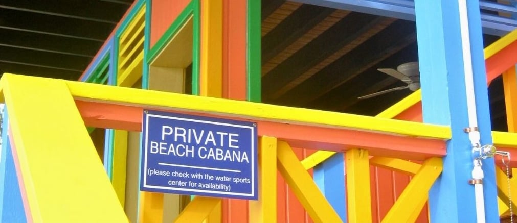 Placas em cabanas de luxo em Half Moon Cay indicando necessidade de reserva.