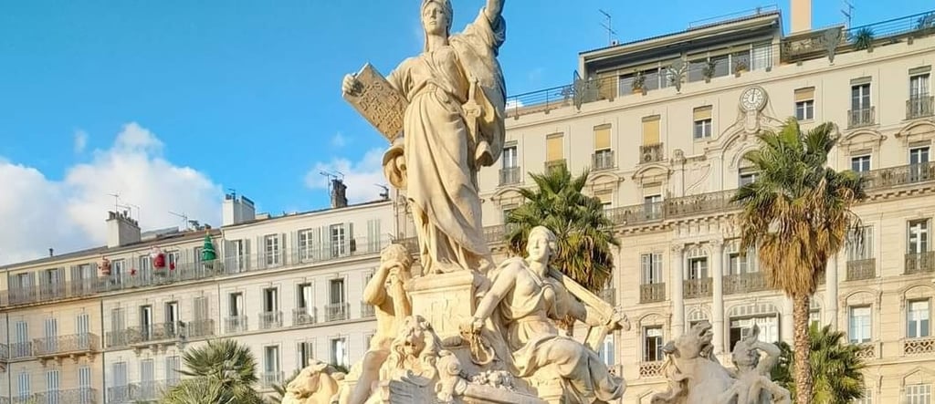 Statue de la Liberté, fontaine à Toulon sur la place, avec immeubles haussmanniens en arrière-plan.