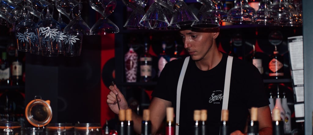 a bartender at a bar with wine glasses and wine glasses