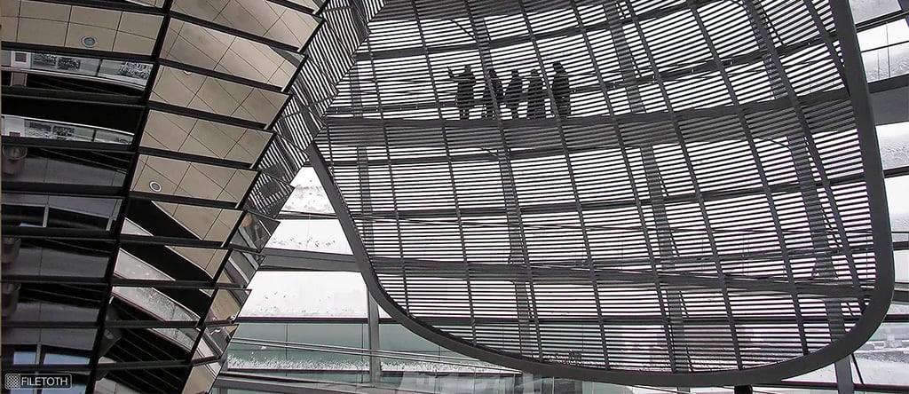 Soft winter daylight filters through glass panels as visitors ascend the spiral ramp inside the Reichstag dome.