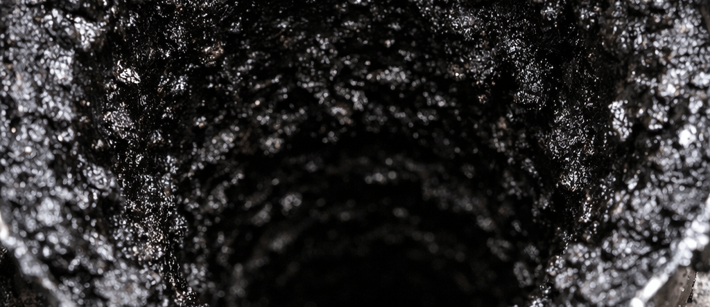 Conduit de cheminée fortement encrassé par du bistre dans une gaine inox, réduisant le tirage 