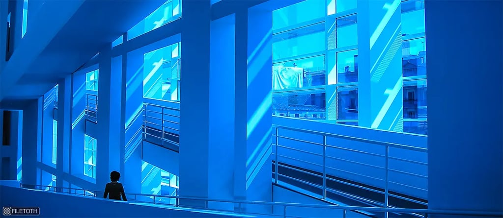 Interior view of MACBA’s atrium where soft daylight filters through the glazed façade, coloring white walls blue.