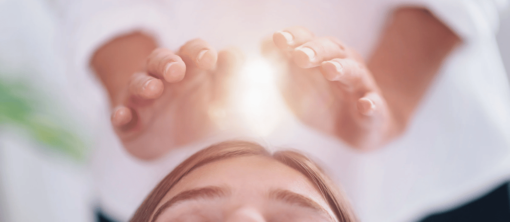 Um terapeuta energizando a cabeça de uma mulher