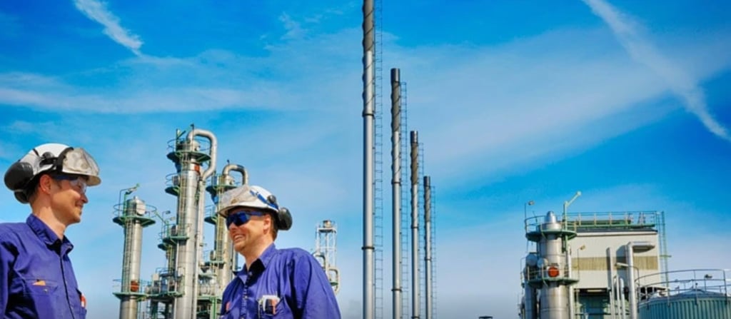 Durraniz Consultants' staff in blue uniforms standing in front of a oil and gas plant