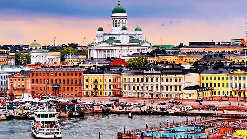 Panoramablick über die Stadt Helsinki mit historischen Gebäuden, dem Hafen und der weißen Domkirche unter hellem nordischem H