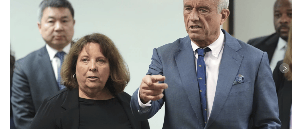 a man in a suit and tie is pointing at a woman in a suit
