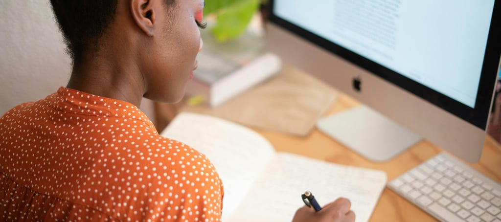 a woman sitting at a desk with a notebook and pen