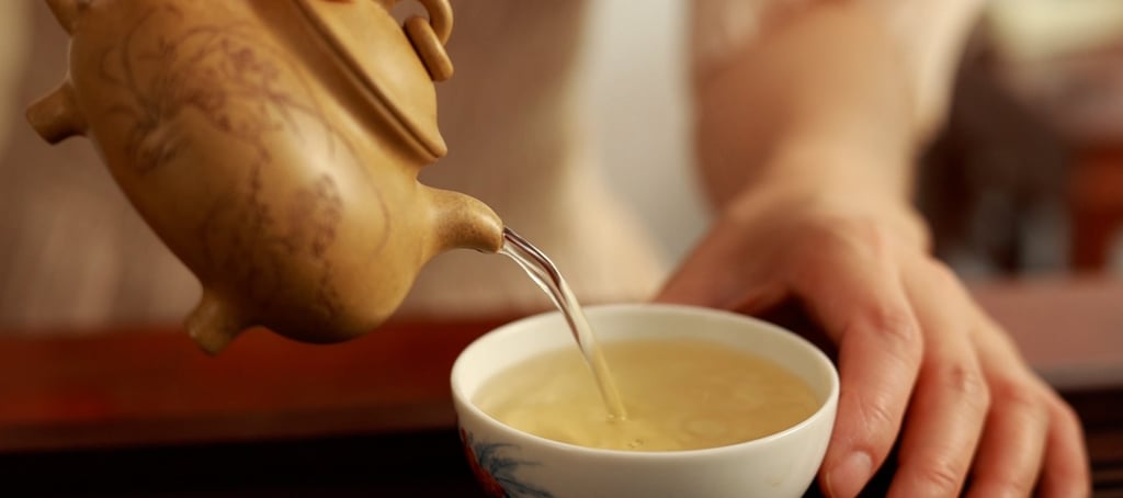 a teapot pouring tea into a teacup