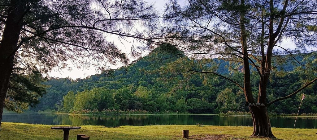 Serene view of Mapanuepe Lake in Zambales with lush green mountains and a peaceful picnic spot, capt