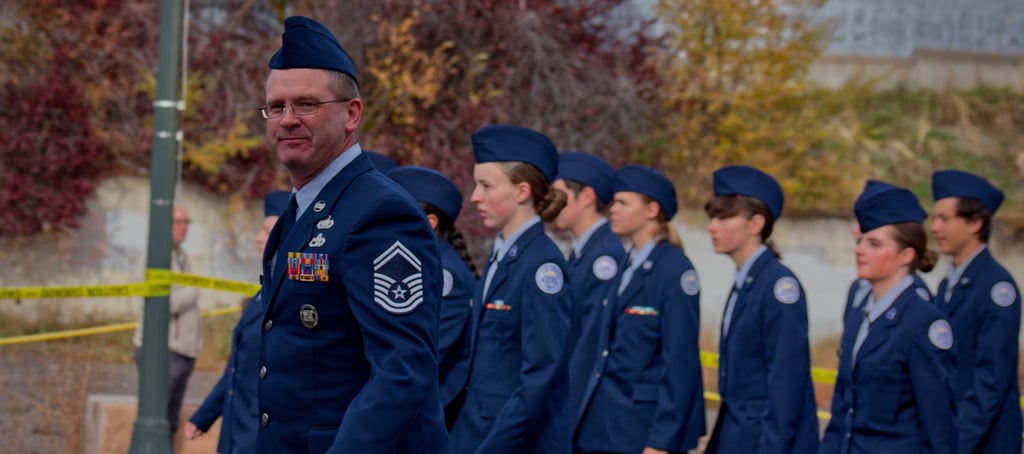 a group of people in uniform uniforms walking down a street