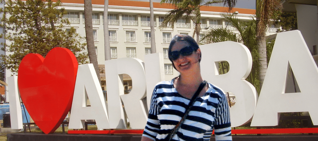 Autora posando em frente ao monumento 'Eu Amo Aruba' em Oranjestad, Aruba
