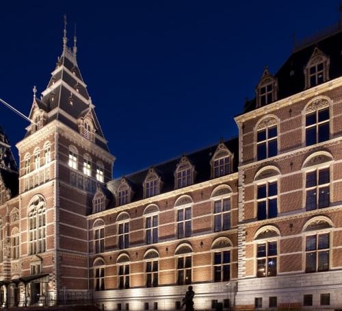 The Rijksmuseum in Amsterdam illuminated at night showcasing Gothic and Renaissance architecture.