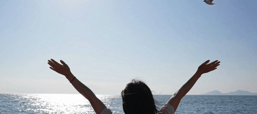 A black and white image capturing a live concert or worship event with people raising their hands. Stage lights and circular hanging structures are visible above the crowd. Text displayed on a large screen reads 'FOR HE ALONE IS WORTHY CHRIST THE LORD'.