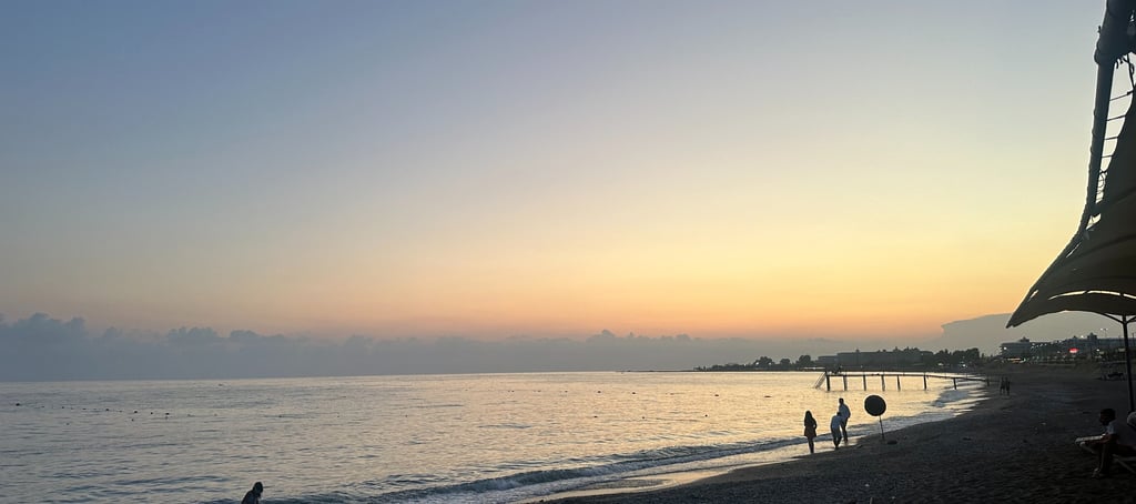 a beach with people walking on the sand