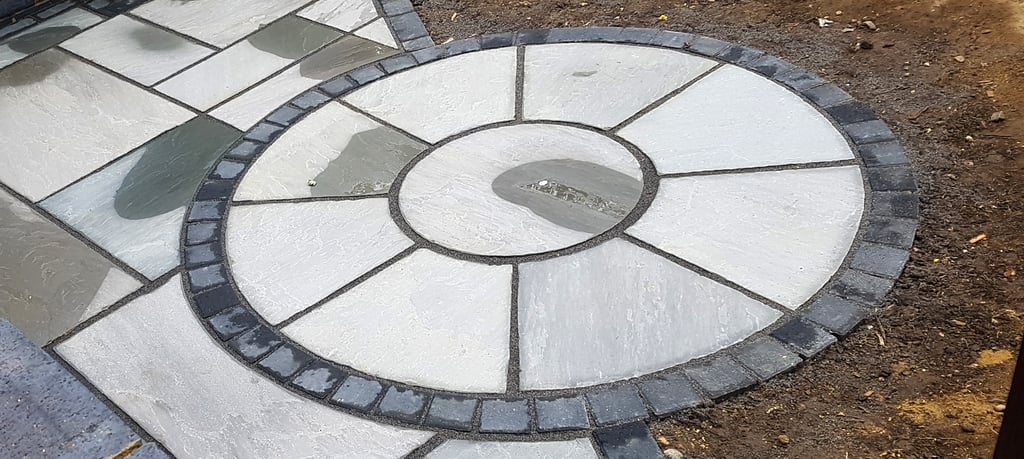 Grey sandstone circle paving slabs with charcoal edging