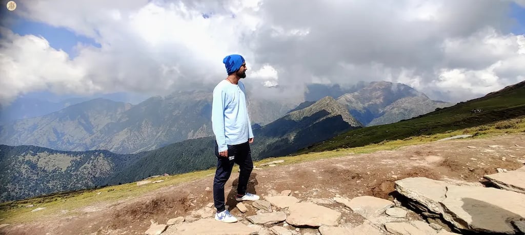 Clouds casting playful shadows on Himalayan mountains, Uttarakhand, serene alpine landscape.