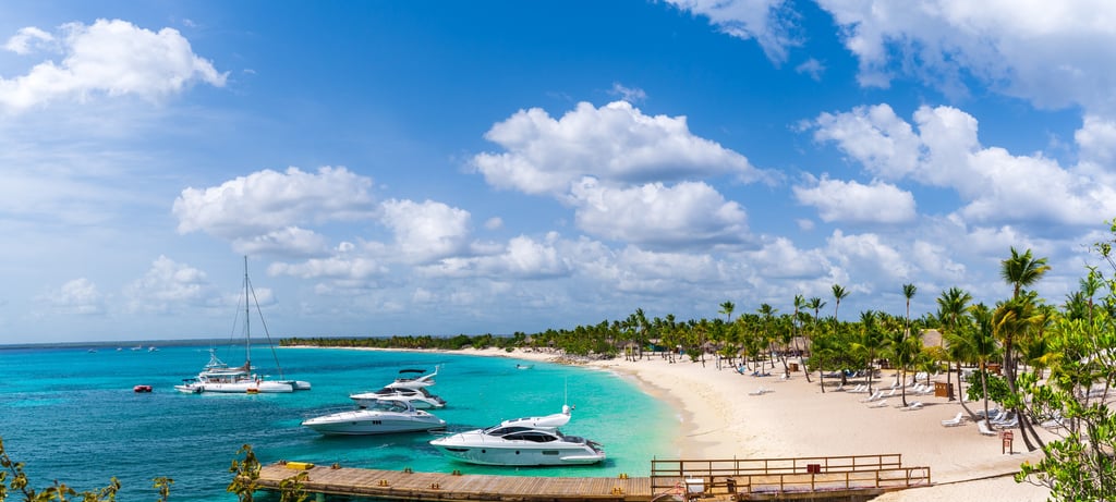 Catalina Island beach with white sand, palm trees, turquoise water, and luxury boats in the Dominican Republic